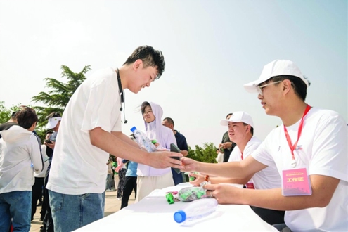 志愿者为选手发放完赛奖牌